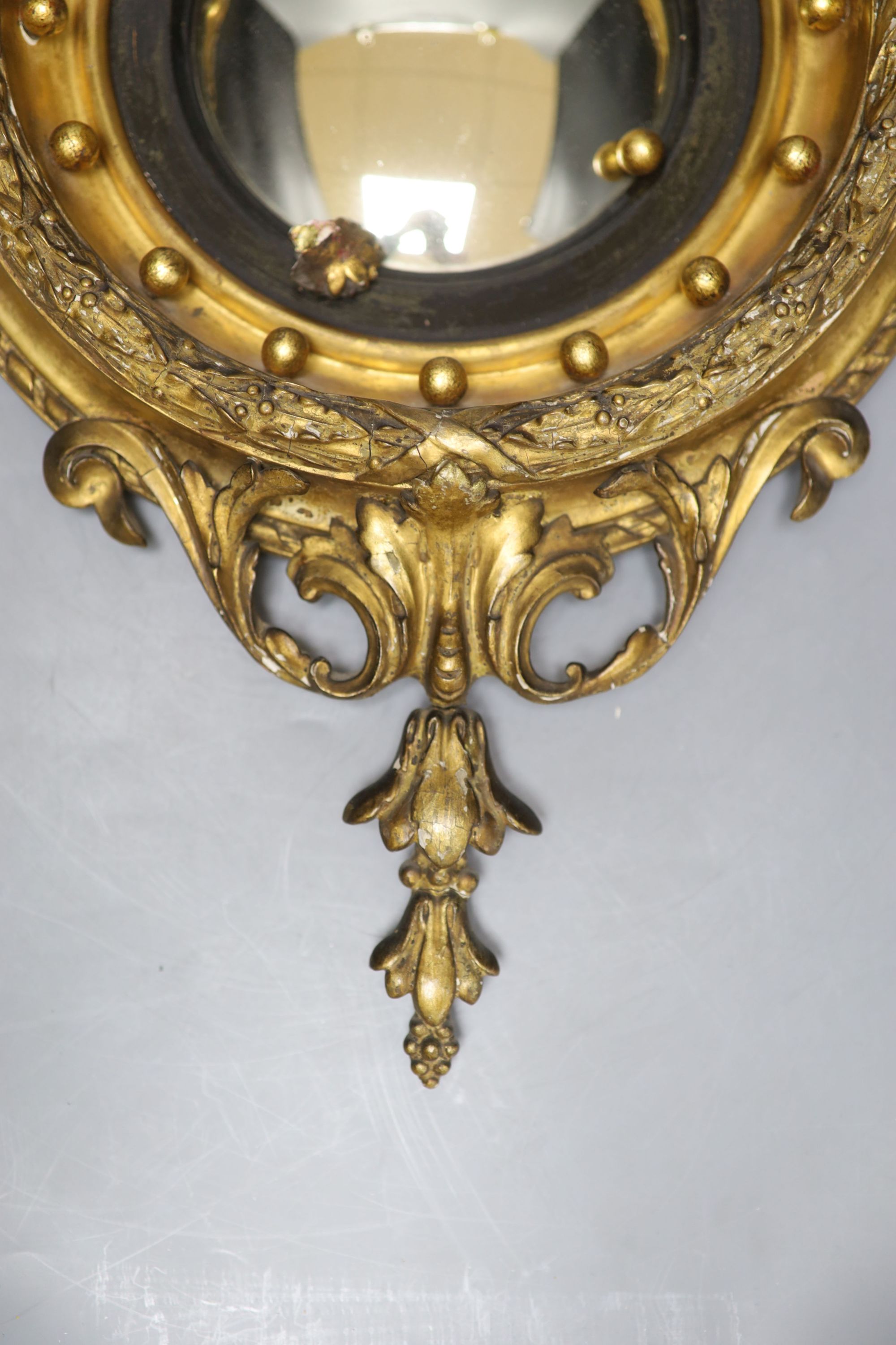 A small Regency style giltwood and gesso convex wall mirror, overall length 49cm